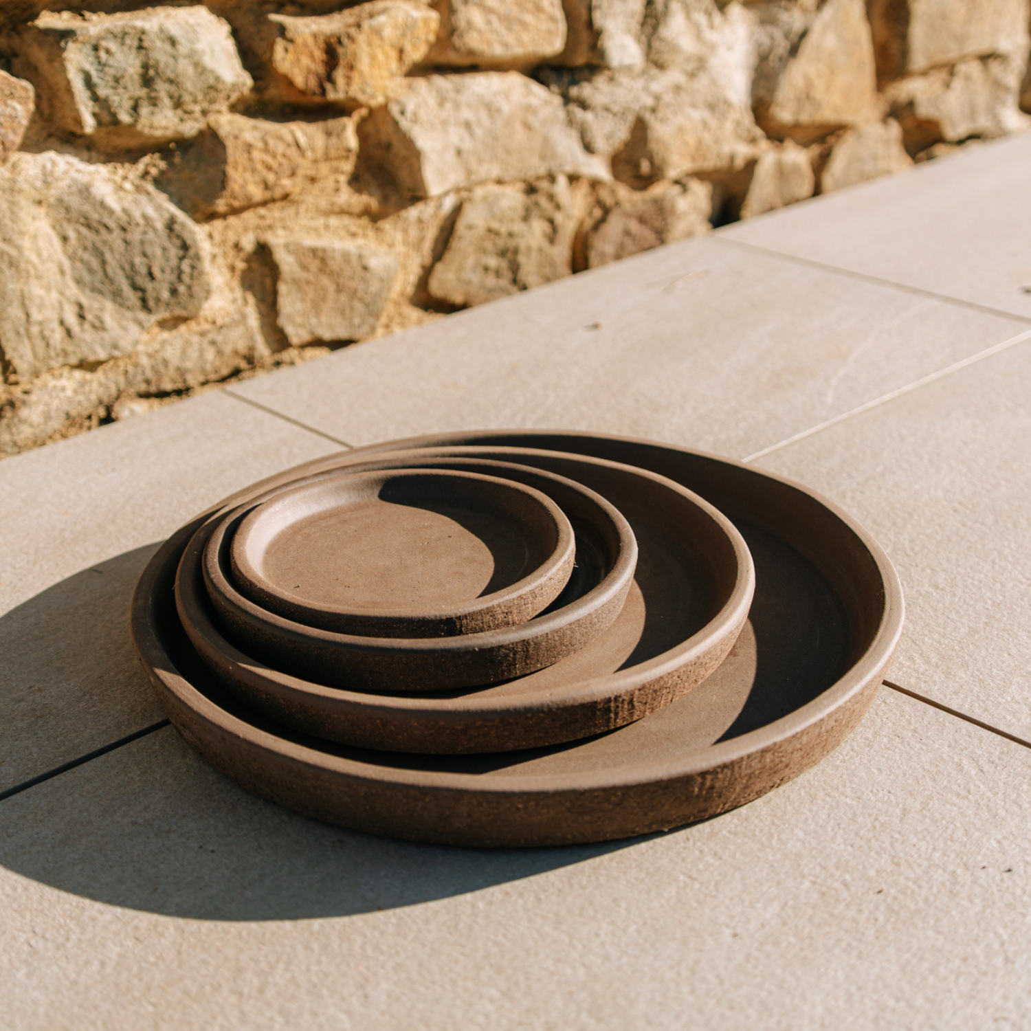 Round 28cm graphite saucer, handmade in terracotta