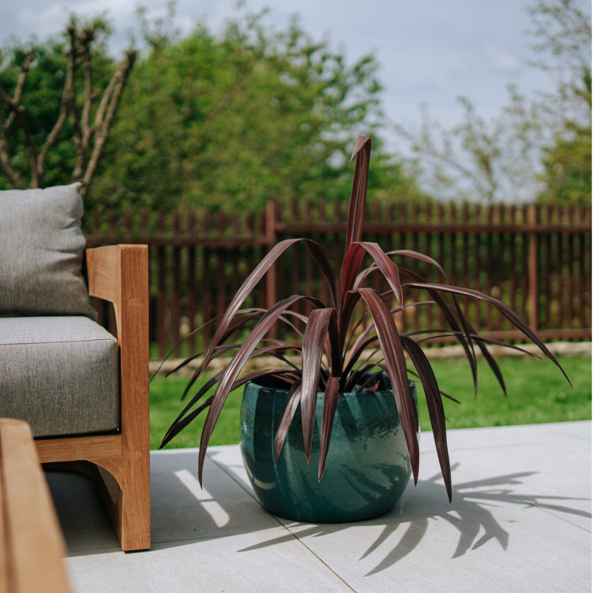 Pot ROMULUS rond 42x30 cm bleu azur en terre cuite émaillée, sur une terrasse avec plante