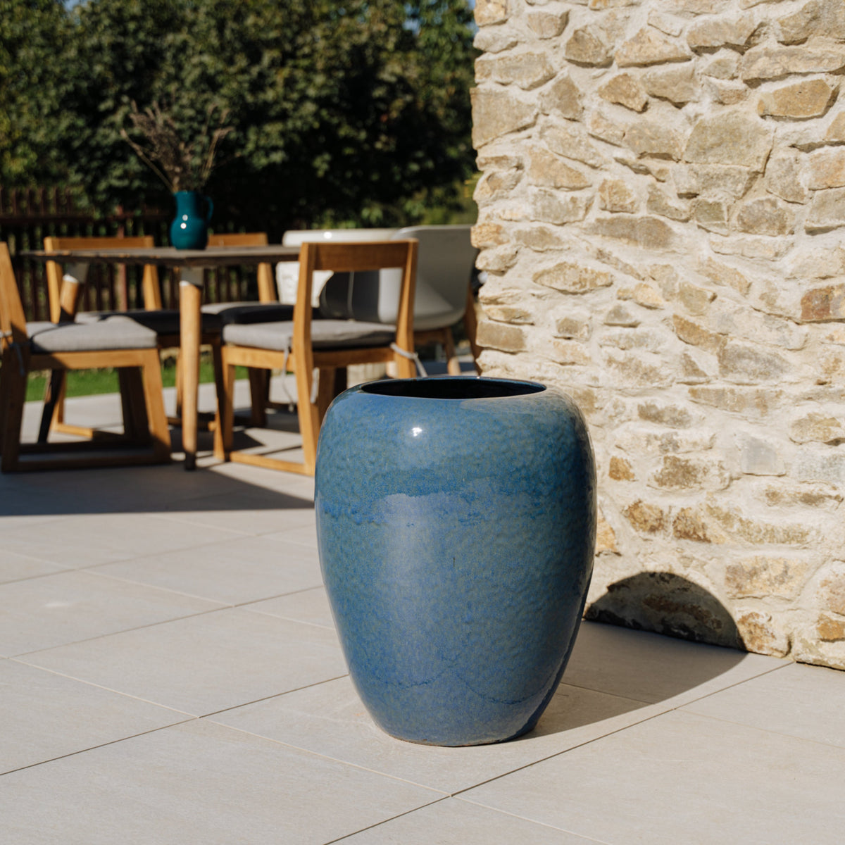 Pot GALILEE décoratif 50x60 cm bleu outremer en terre cuite émaillée, vide sur une terrasse près d’une table