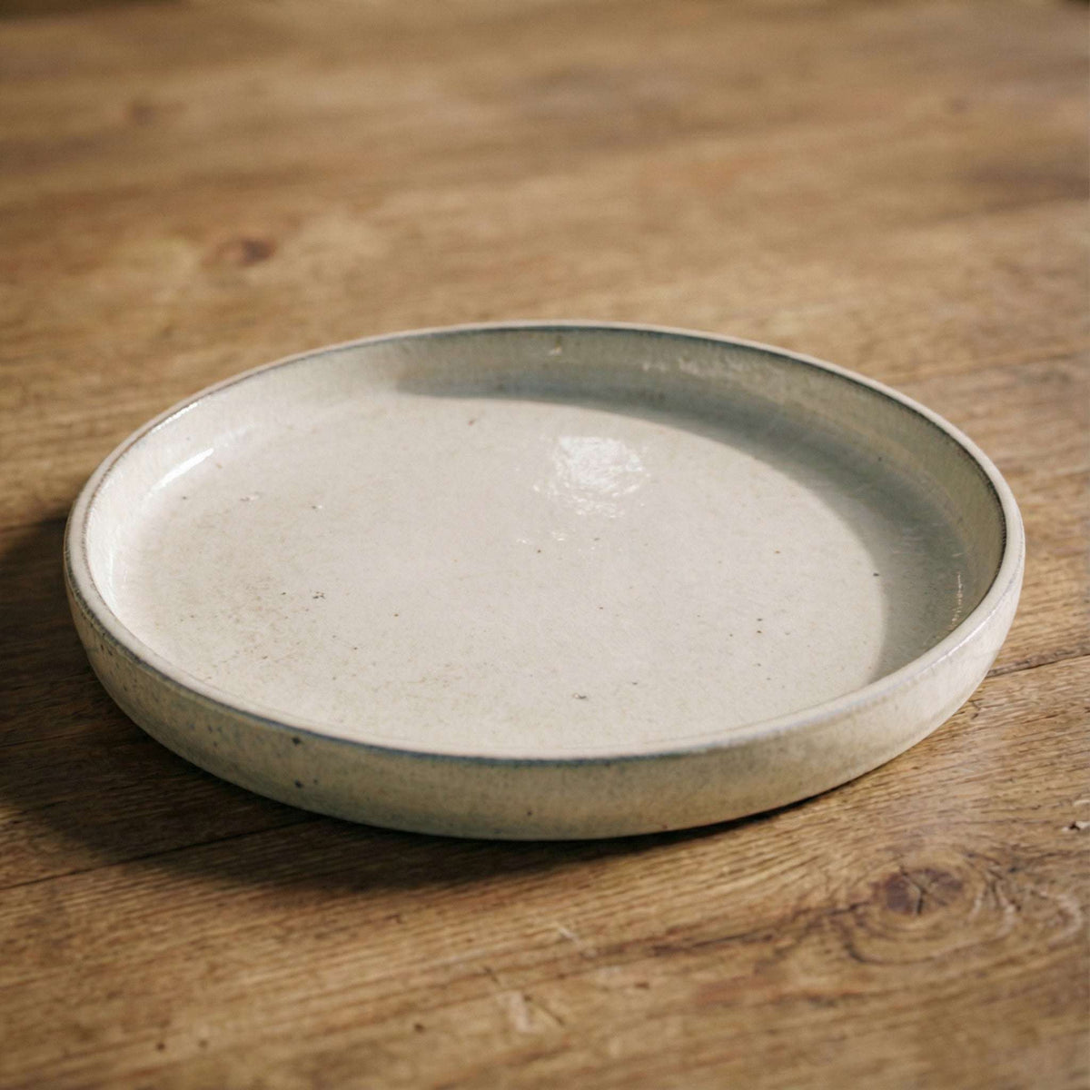 Cream saucer, three-quarter view on a table
