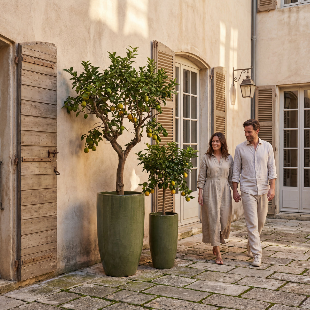 Eiffel Deep green glazed ceramic planter, in front of a house with passers-by