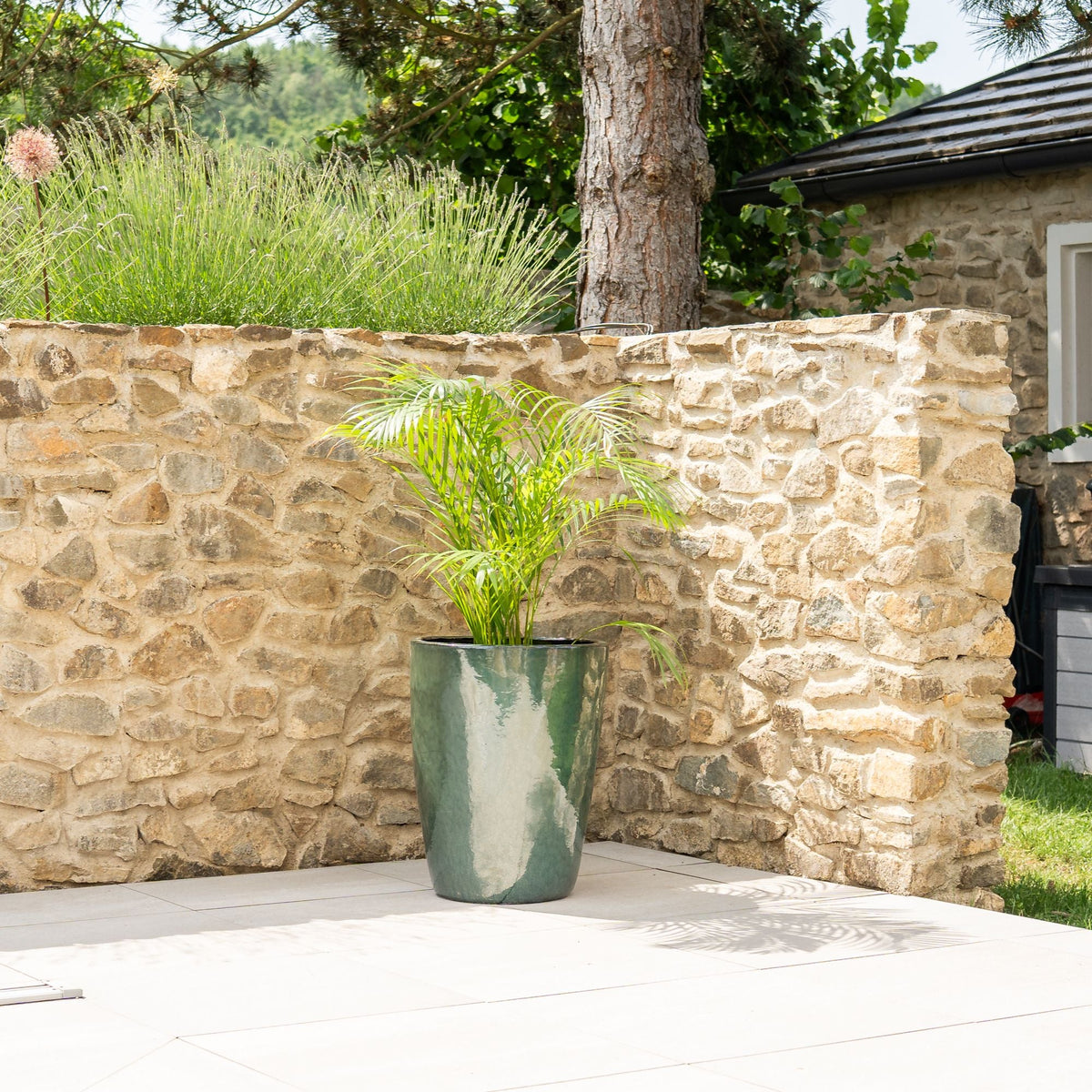 Macetero decorativo Mazarin de 45 × 58 cm, jade, de cerámica esmaltada, con palmera en una terraza