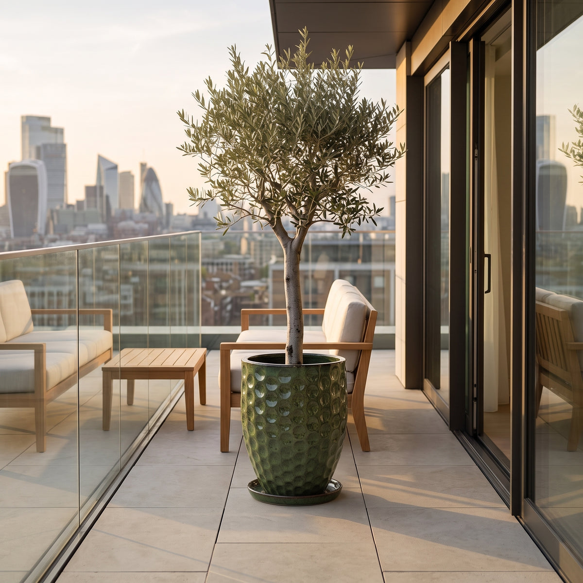 Macetero Merovee con forma de ánfora de 42x55 cm Verde tropical en cerámica esmaltada, olivo en un balcón