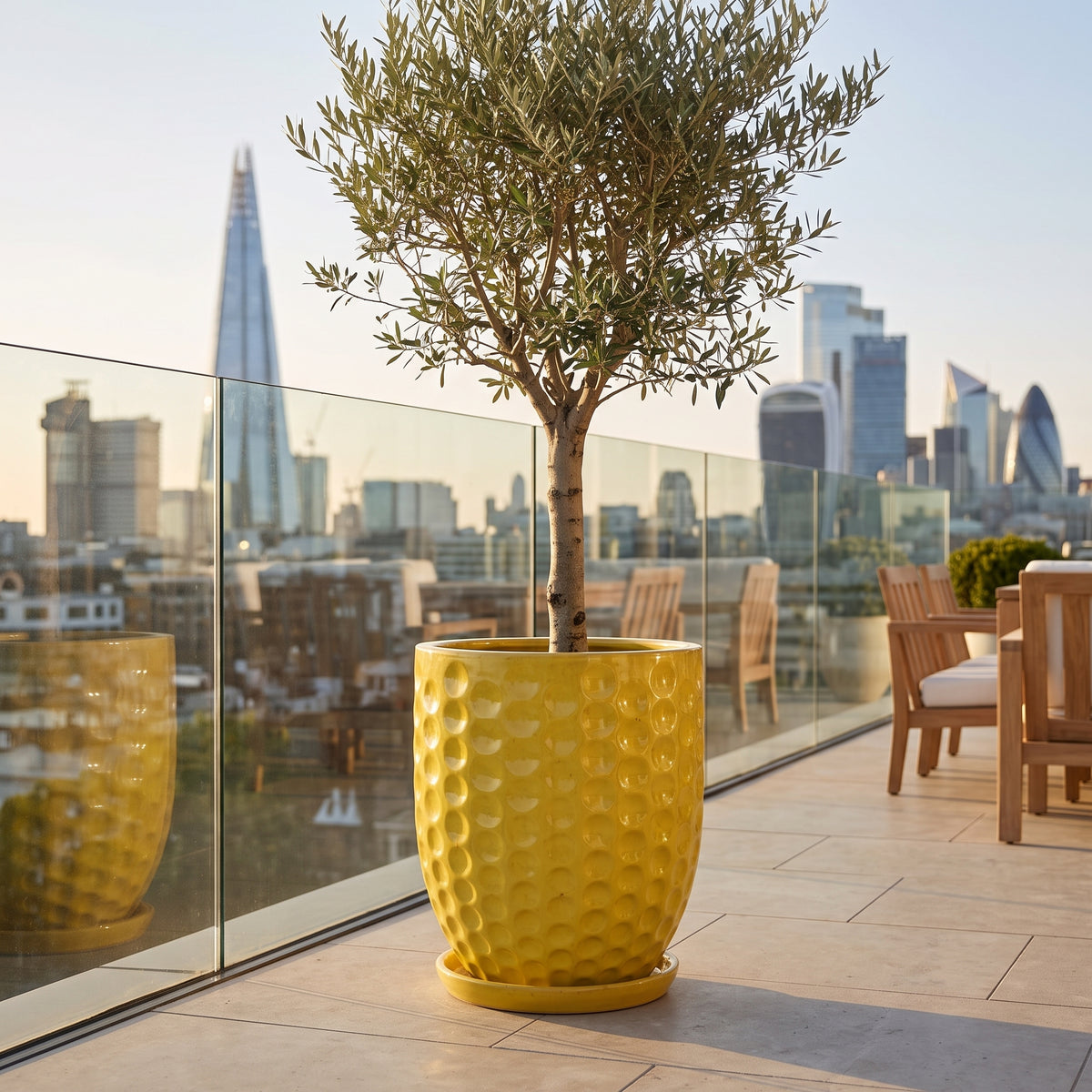 Vaso Merovee a forma di anfora 55x65 cm giallo in ceramica smaltata, con olivo su una terrazza urbana