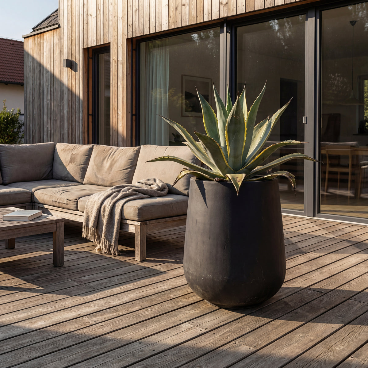 Portavaso preforato Silex Nero opaco in calcestruzzo fibrorinforzato, vicino a un salotto da terrazza