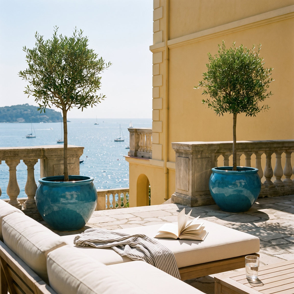 Pot LUTECE rond 53x43 cm bleu caraïbes en terre cuite émaillée, avec oliviers sur terrasse face à la mer