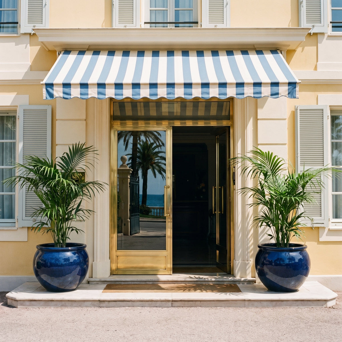 Round LUTECE planter 53x43 cm in Midnight Blue glazed ceramic, in front of an entrance with palm trees