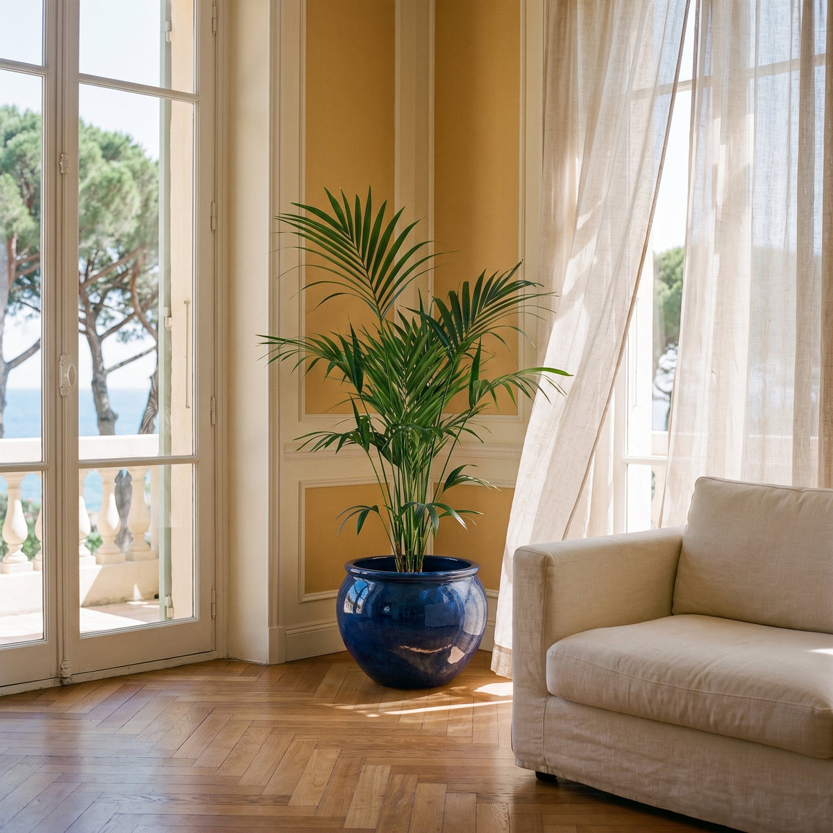 Vaso LUTECE rotondo 53x43 cm blu notte in ceramica smaltata, con una palma in un soggiorno