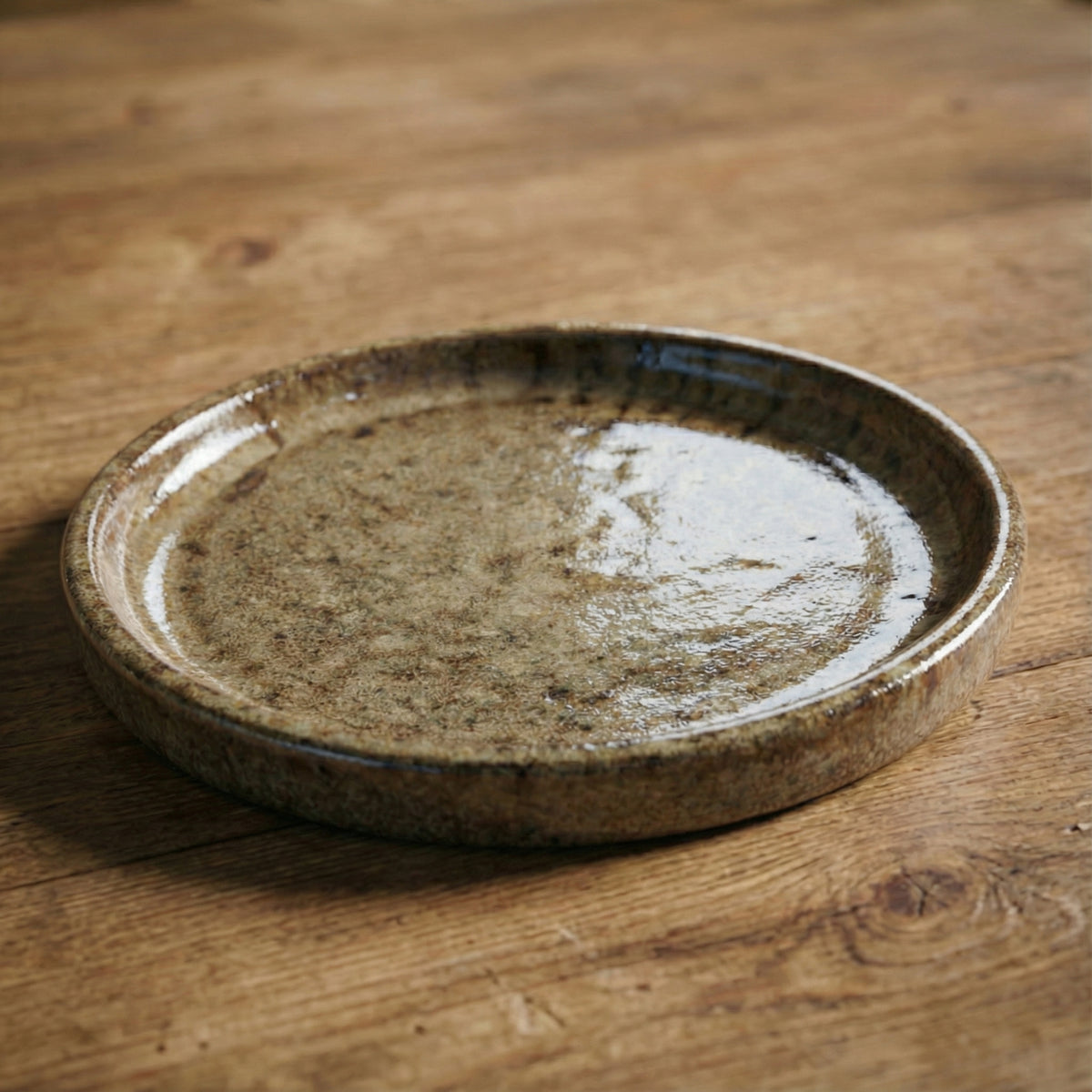 Sandblasted bronze saucer, three-quarter view on wood