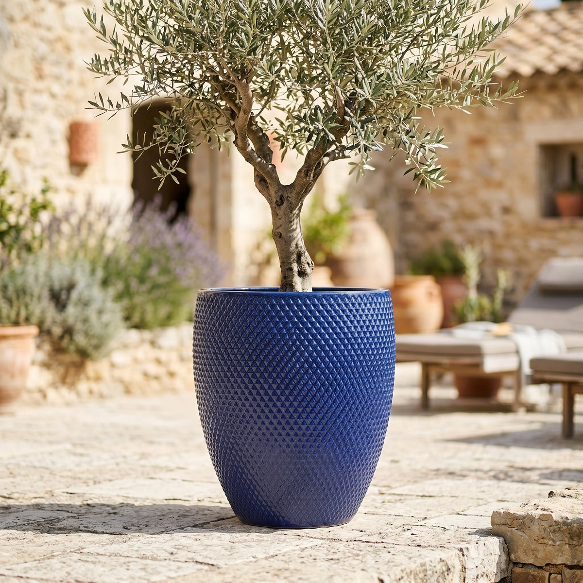 Macetero Signac decorativo 38x44 cm Azul cobalto de cerámica esmaltada, olivo en una terraza de piedra