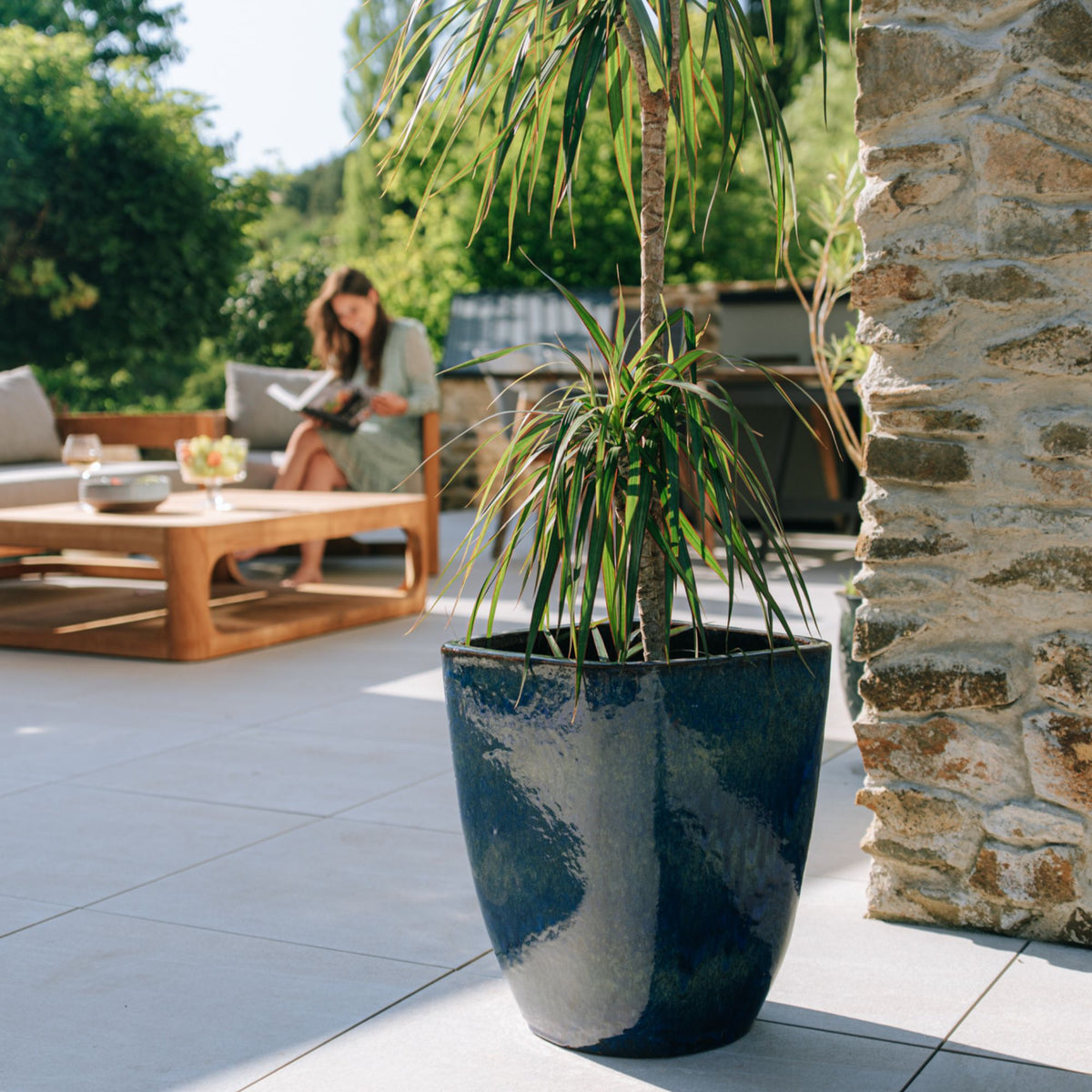 Macetero Vauban rectangular 34x43 cm azul ultramar de cerámica esmaltada, plantado con una drácena en la terraza