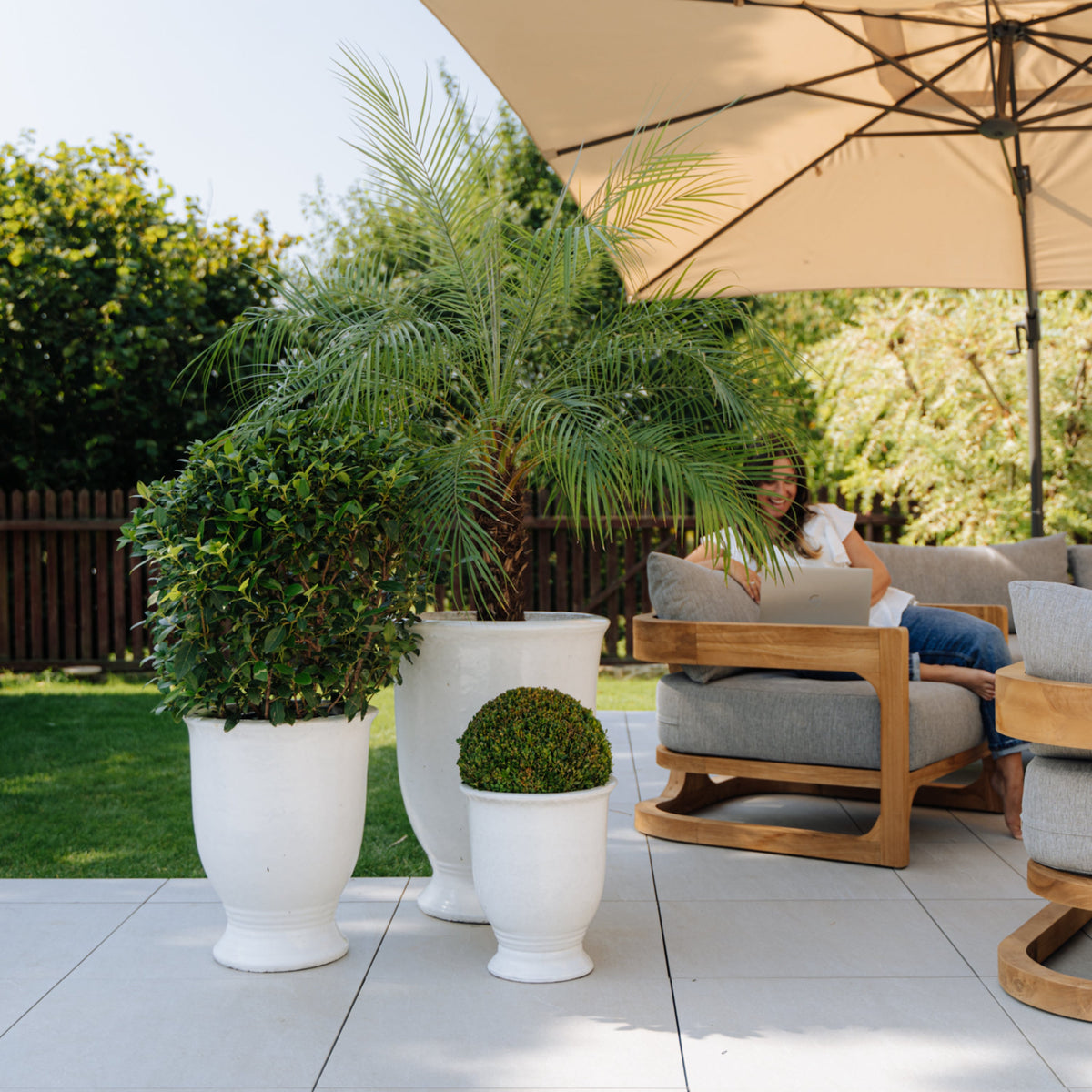 White glazed ceramic Arthur planter with stand, planted planters on a terrace