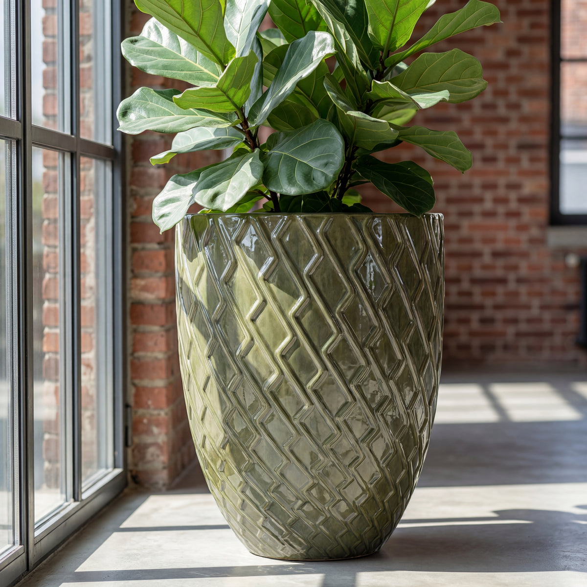 Vaso Zeus Verde crema in ceramica smaltata, con pianta verde vicino a una finestra