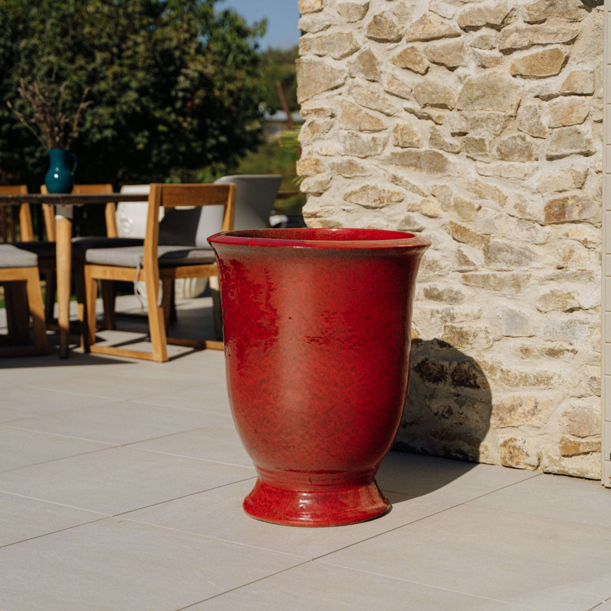 Pot Arthur avec pied 42x52 cm rouge tropical en terre cuite émaillée, posé sur une terrasse