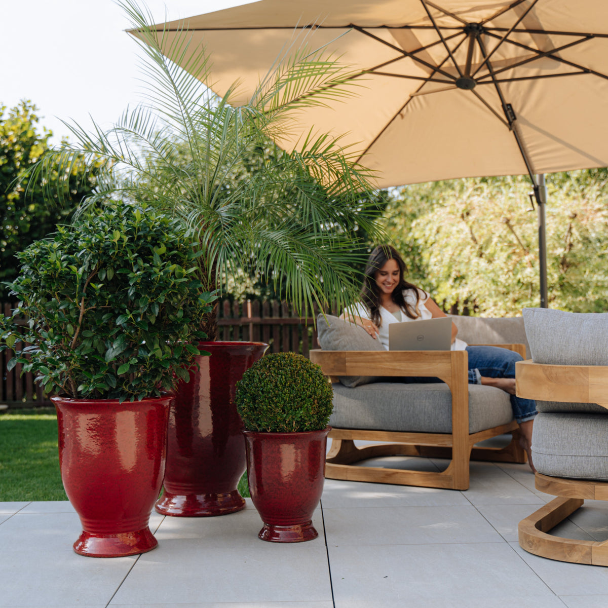 Arthur planter with base Tropical Red glazed ceramic, among three planters under a parasol