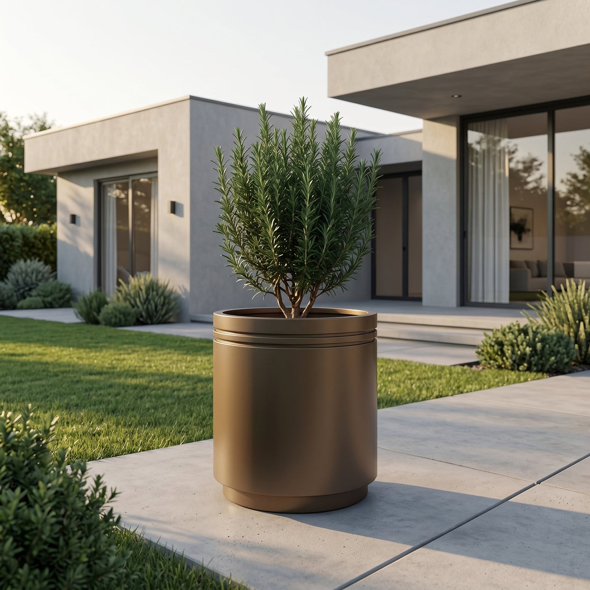 Cylindrical Infinity round planter 60x60 cm taupe in galvanised metal, with shrub in front of a house