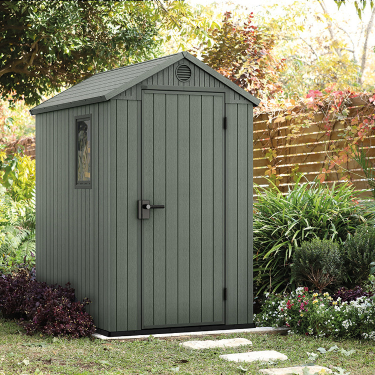 Groen Darwin 4x6-tuinhuisje in een bloeiende tuin, vooraanzicht