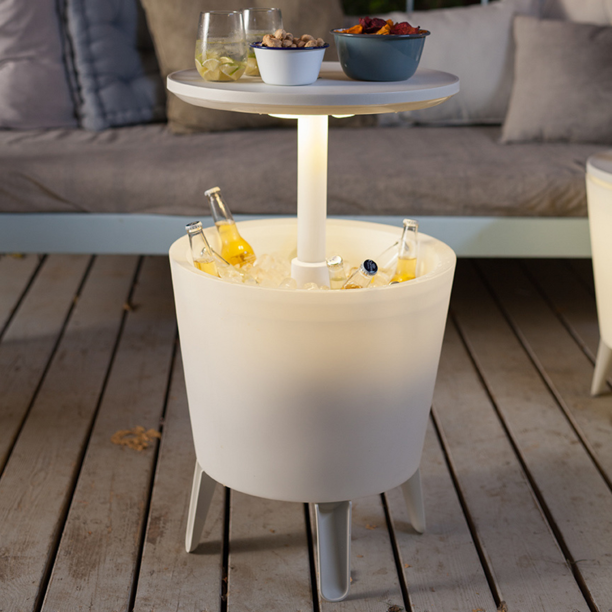 Verlichte witte Cool Bar, open met flessen en blad op een terras