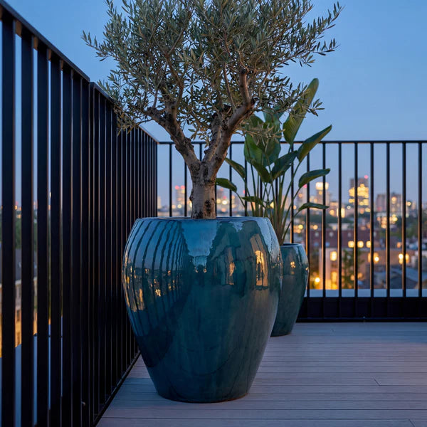 Lafontaine2 amphora-shaped Jade mist glazed ceramic planter, on a terrace at dusk