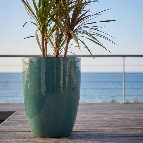 Macetero Mazarin2 Bruma de jade de cerámica esmaltada, con plantas esbeltas en una terraza