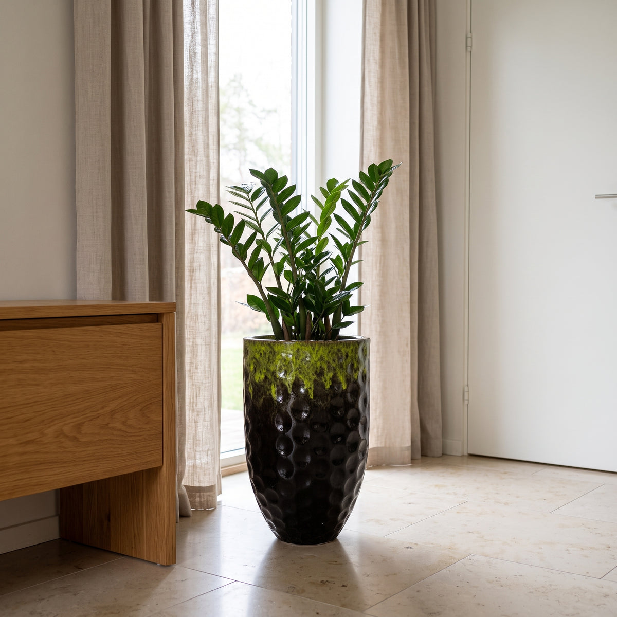 Pot Merovee en forme d'amphore 30x45 cm noir et vert en terre cuite émaillée, plante verte près d'une fenêtre