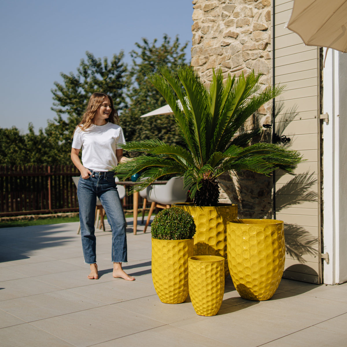 Merovee amphora-shaped planter 30x45 cm yellow glazed ceramic, among several planters on a terrace