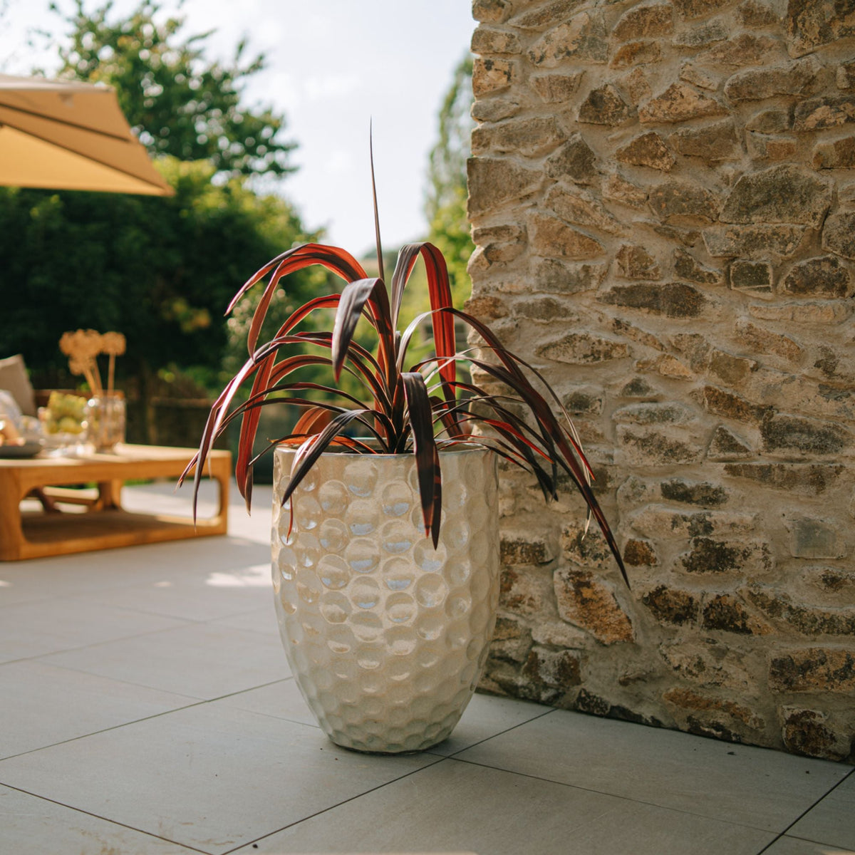 Macetero Merovee con forma de ánfora 42x55 cm perla de cerámica esmaltada, con planta roja en terraza