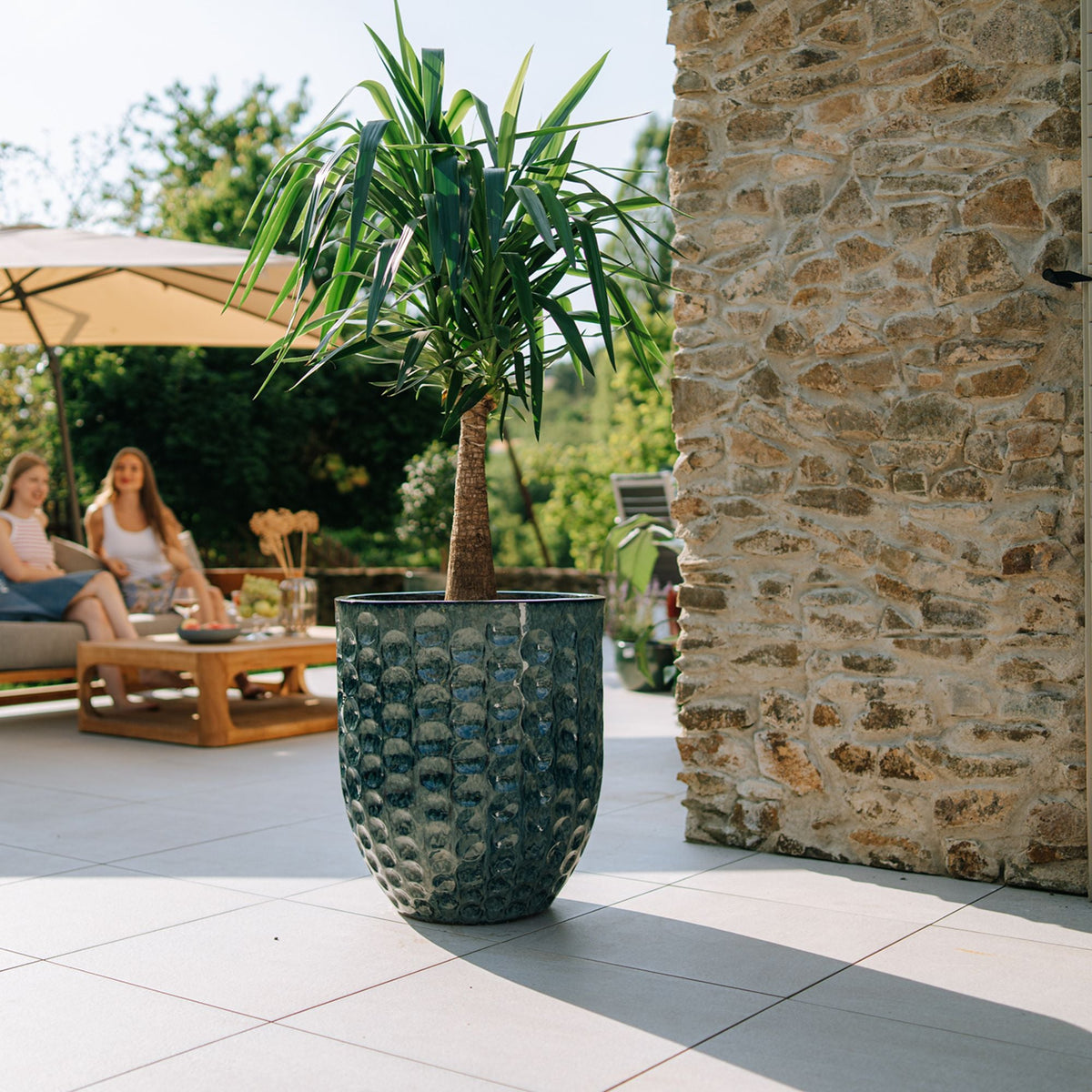 Merovee amphora-shaped planter 55x65 cm Abyss Blue in glazed ceramic, with a dracaena on a terrace