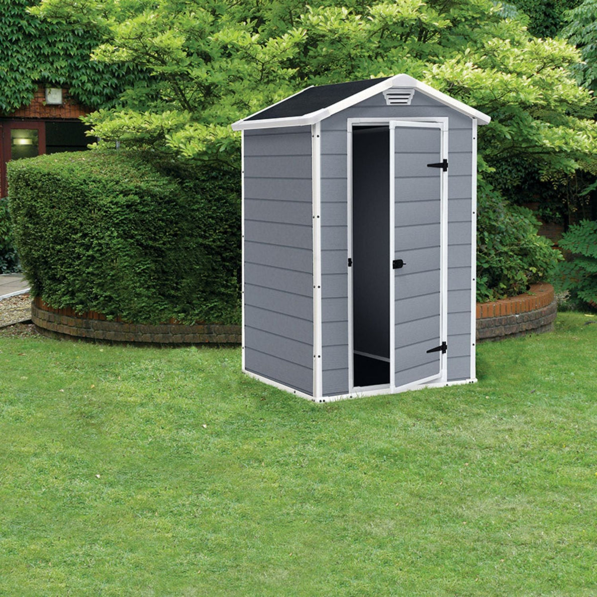 Abri de jardin MANOR 4x3 gris ouvert installé sur une pelouse