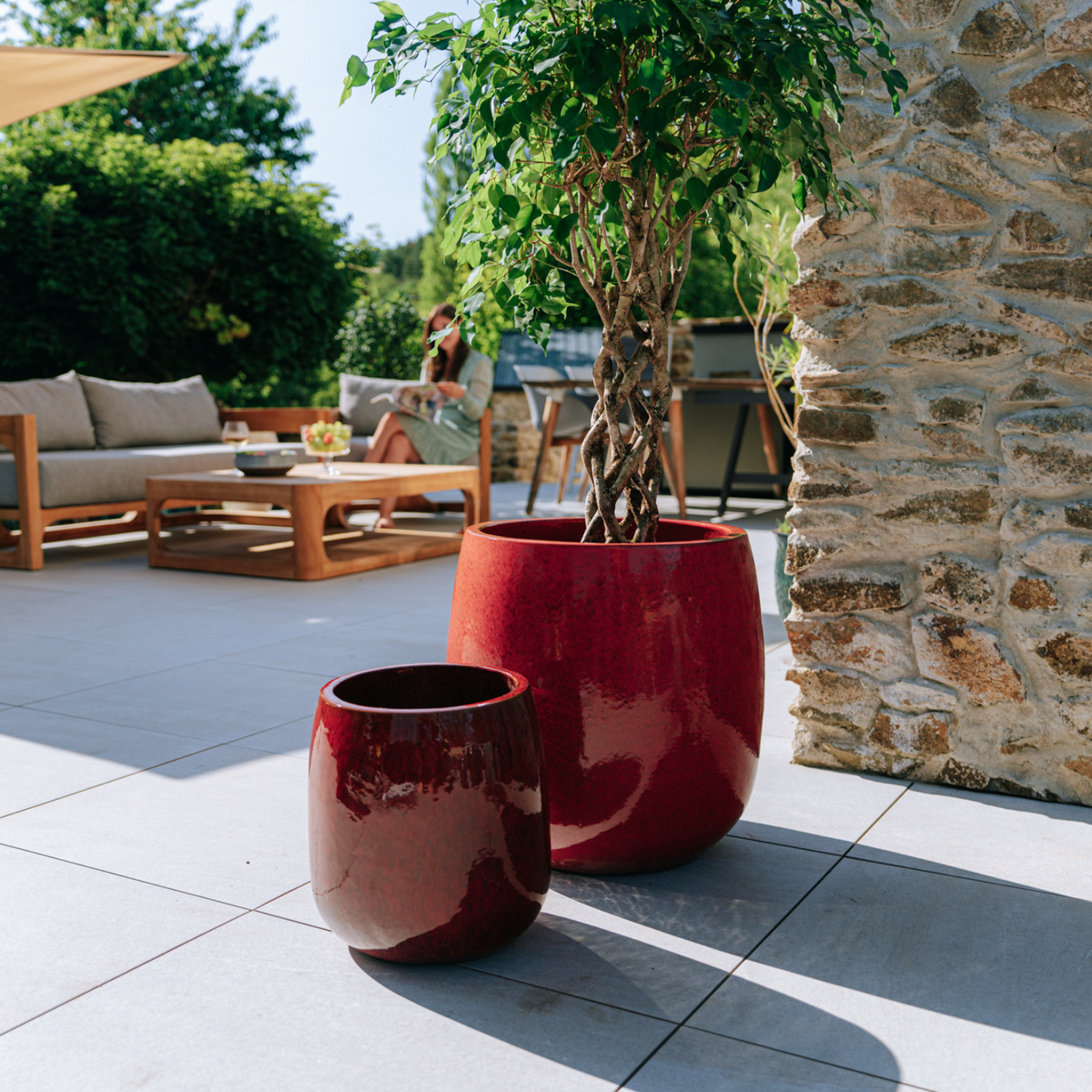 Pot Socrate rond 40x49 cm rouge tropical en terre cuite émaillée, parmi deux pots sur la terrasse