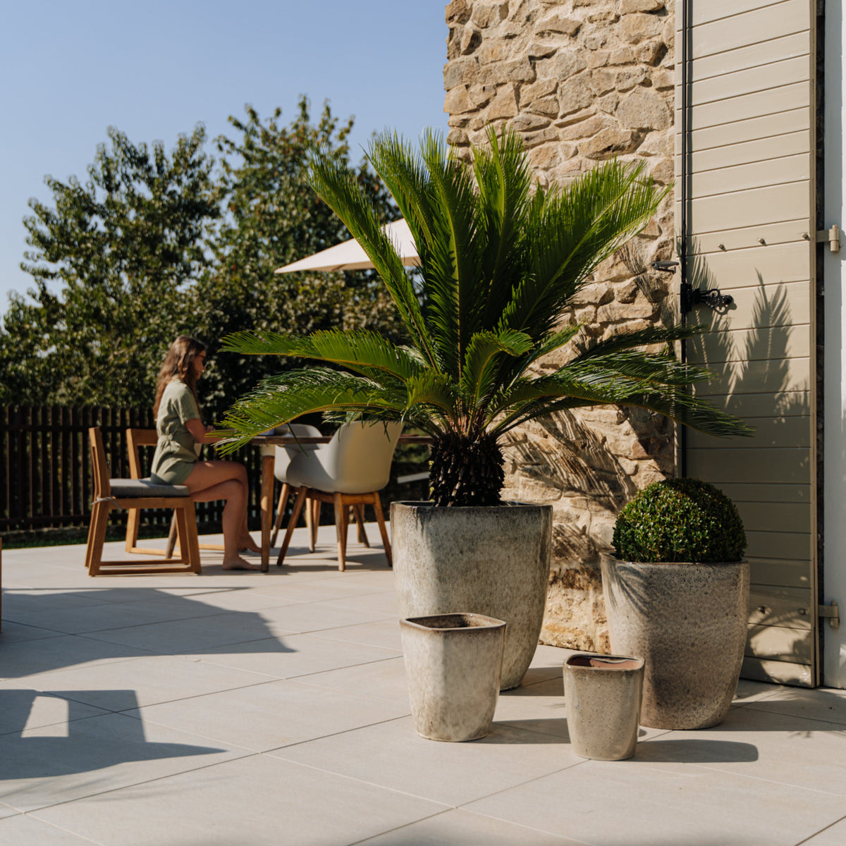Pot Vauban rectangle blanc tigré en terre cuite émaillée, près d'une table en terrasse