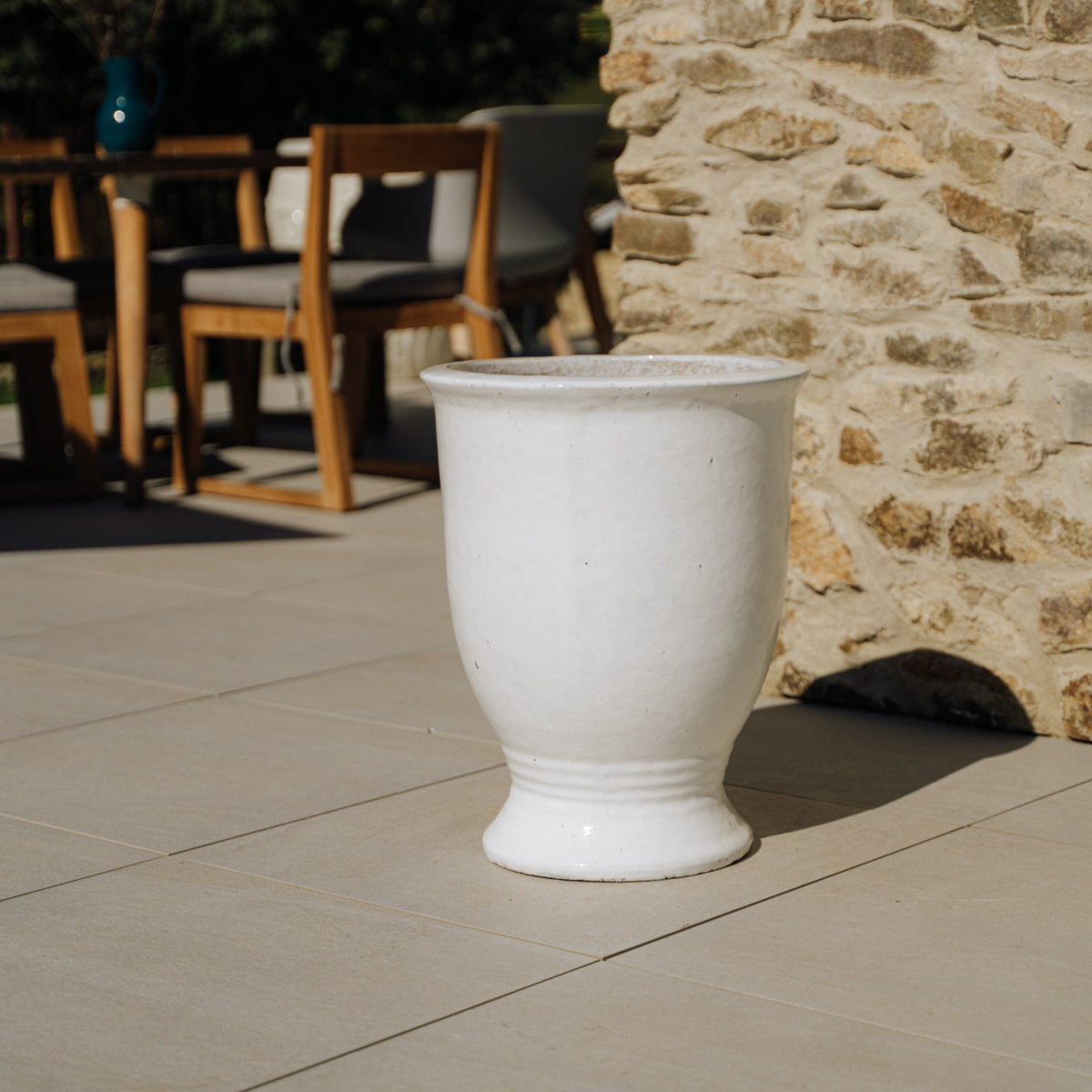 Pot Arthur avec pied 55x69 cm blanc en terre cuite émaillée, posé sur une terrasse en pierre